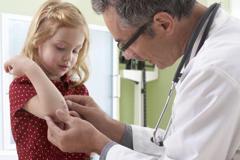 doctor examines a child with psoriasis
