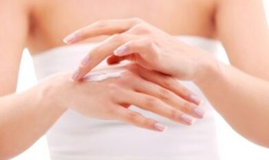 a girl applying salve to her hand